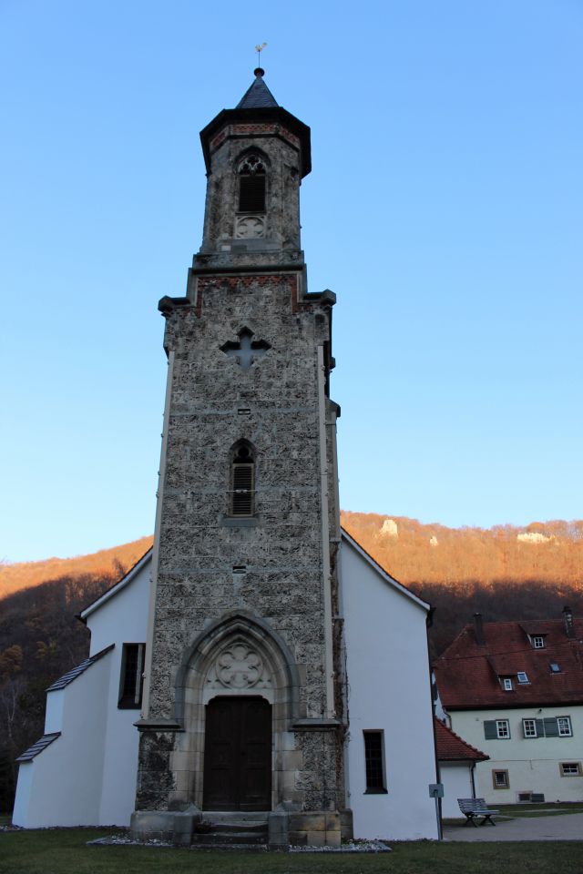 Der Turm der Kirche ist aus quadratischen Tuffsteinen aufgemauert. Die anderen Teile der Kirche sind weiß getüncht.