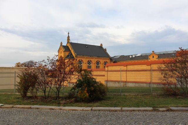 Das 'Gelbe Elend'. Die Haftanstalt wurde aus gelblichen Backsteinen errichtet. Links eine moderne Betonmauer, rechts aus Backsteinen.