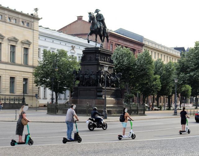 Von seinem Reiterstandbild scheint der Alte Fritz auf vier Personen herabzublicken, die auf der Straße passieren.