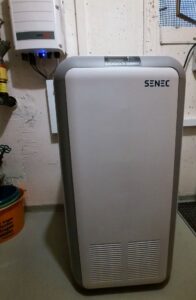 Ein grauer Kunststoffschrank mit der Aufschrift SENEC.