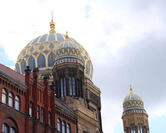 Die blau-goldfarbene Kuppel auf einem Gebäude und zwei kleine Türme mit Kuppeln gehören zum Gebäude der Stiftung Neue Synagoge in Berlin.