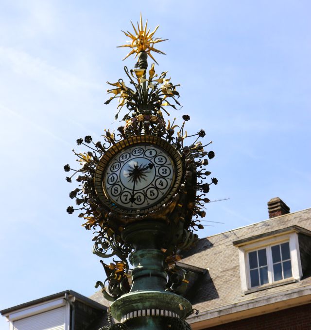 Eine schmuckvoll gestaltete Uhr auf einem Pfahl. Sie ähnelt einem Stern.